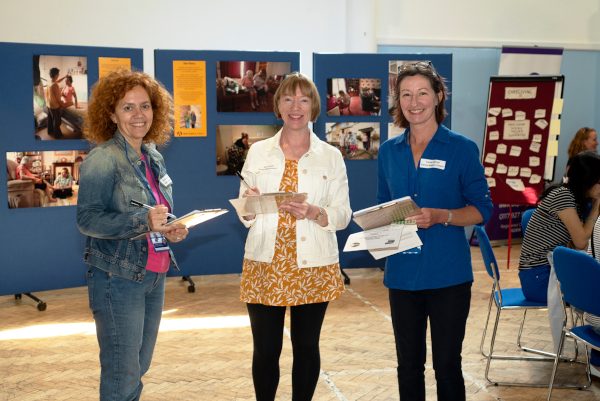 Three Carers Support staff members stand smiling at the camera during Carer's Week